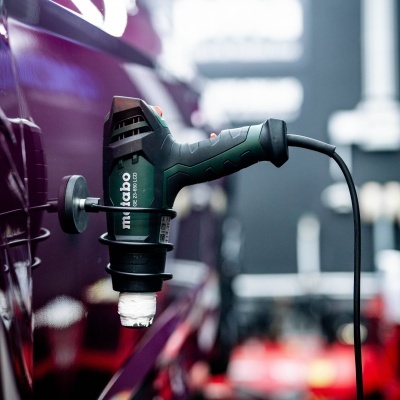 Politriz elétrica Metabo PE 12-180 150 em uso na carroceria de um carro roxo