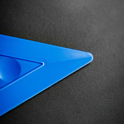 Esquadro triangular azul em plástico sobre superfície preta