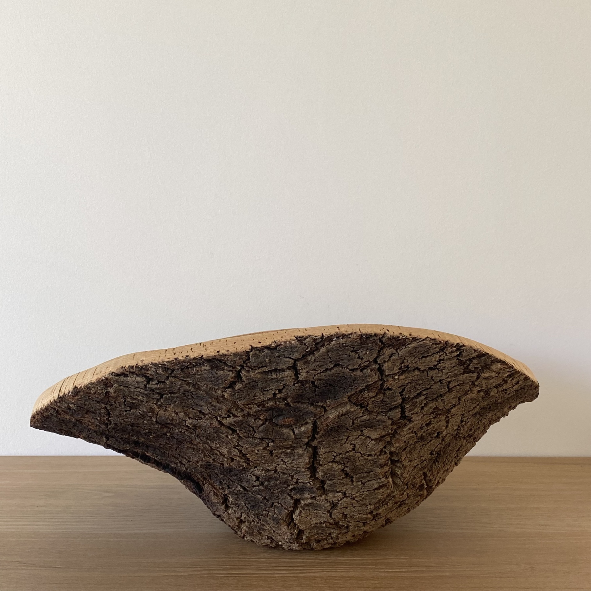 TAÇA EM CORTIÇA NATURAL Pedaço de madeira com casca natural sobre superfície de madeira clara