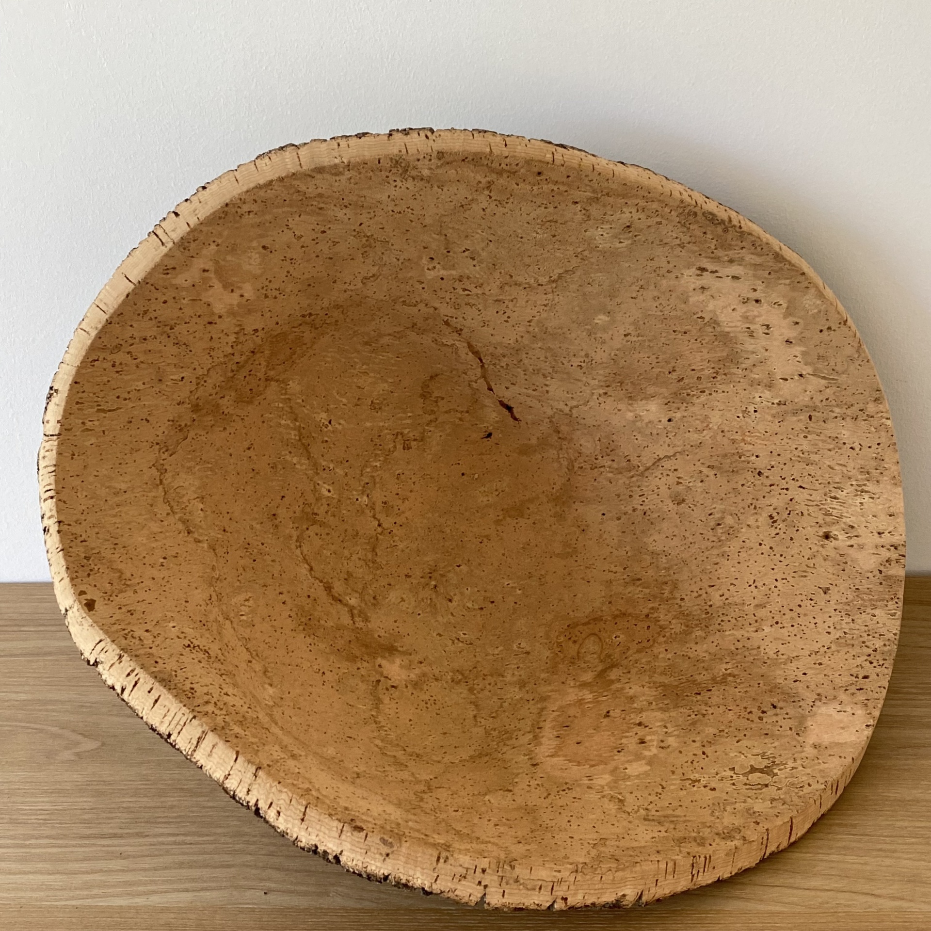TAÇA EM CORTIÇA NATURAL Prato ou tigela de cortiça natural sobre mesa de madeira.
