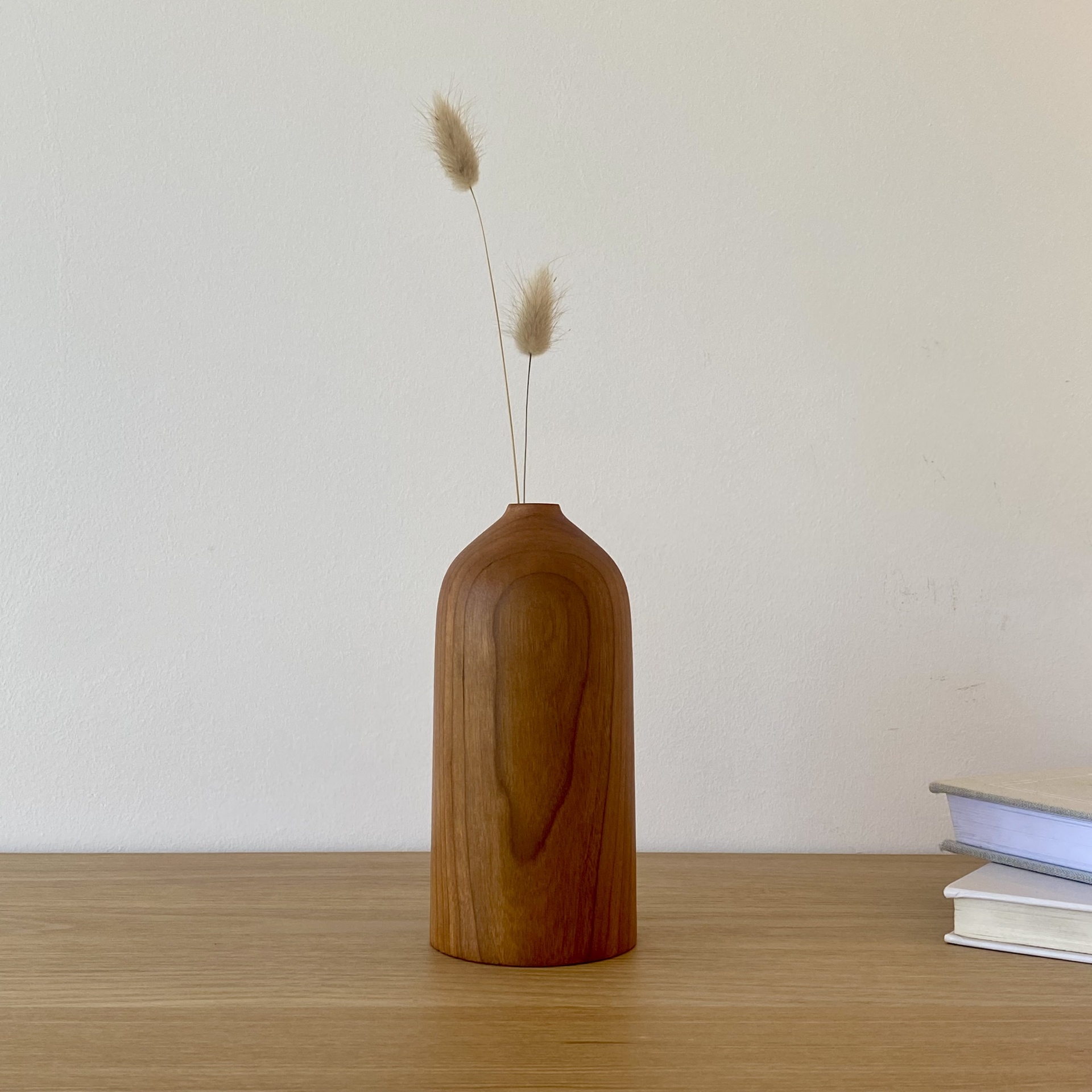 JARRA EM MADEIRA DE CEREJEIRA Vaso de madeira com ramos secos numa mesa ao lado de livros