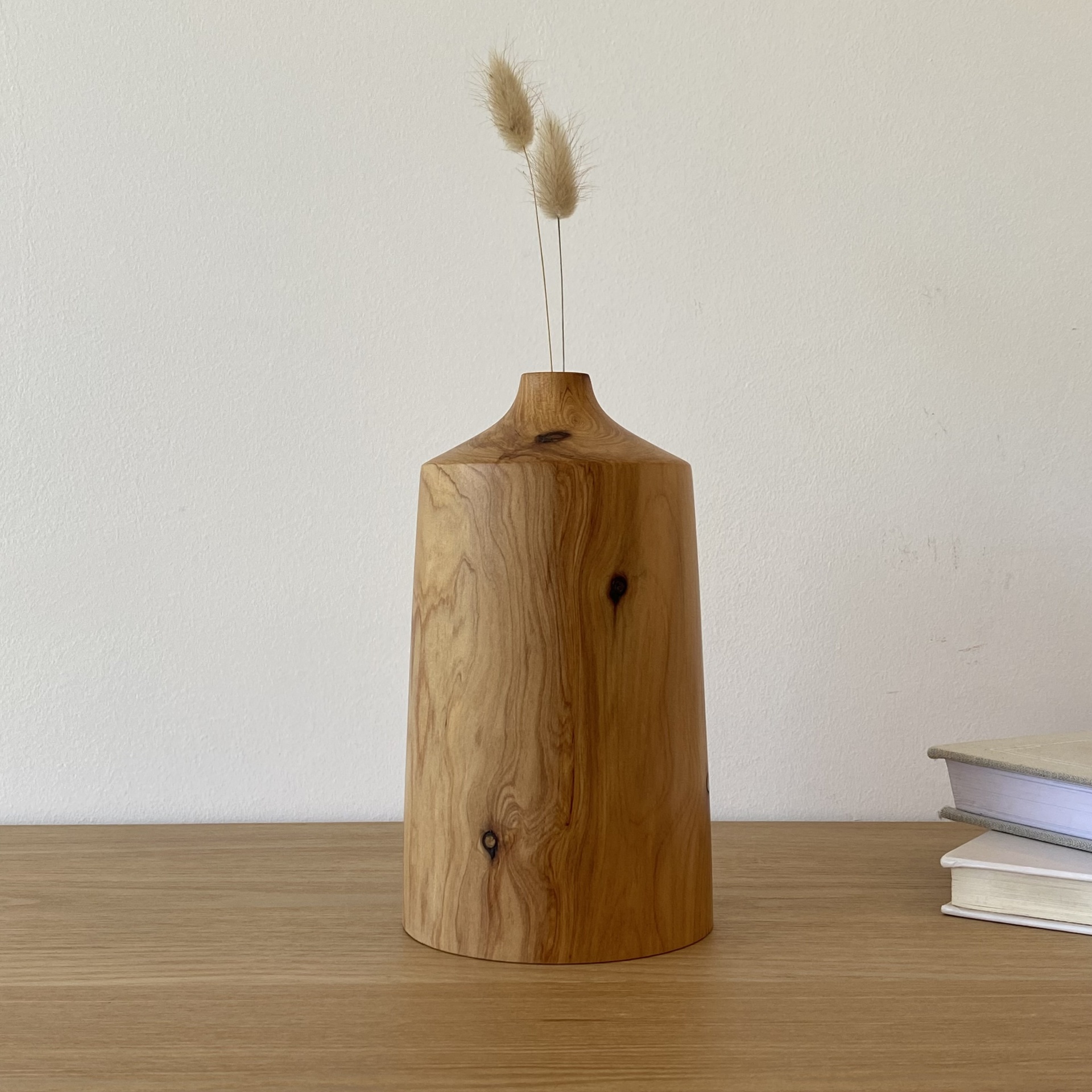 JARRA EM MADEIRA DE CEDRO Vaso de madeira natural cilíndrico com ramos secos numa mesa de madeira