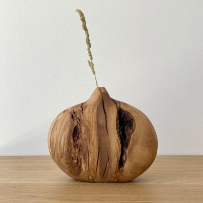 Vaso decorativo de madeira com textura rústica e haste seca inserida