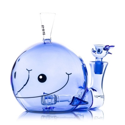 Objeto de vidro azul em forma de baleia com rosto sorridente em fundo branco