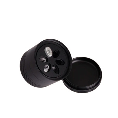 Moedor de ervas preto em metal com quatro lâminas internas e tampa separada.