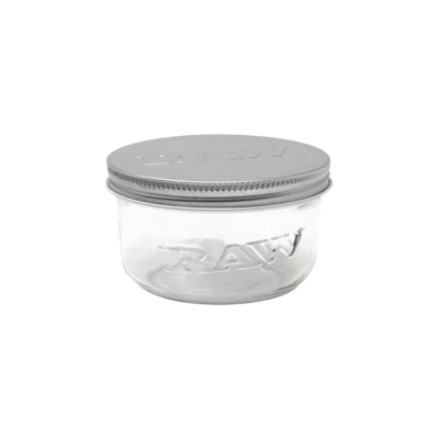 Recipiente de vidro transparente com tampa metálica prateada e palavra RAW em relevo