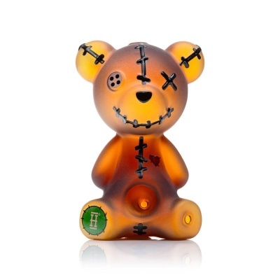 Figura de urso em resina castanha alaranjada com desenhos de suturas e botão no olho.