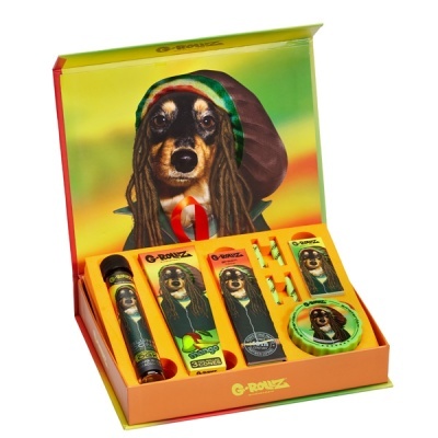 Conjunto de papel de enrolar G-Rollz com tema de cão rastafári, embalagem colorida e produtos organizados na caixa