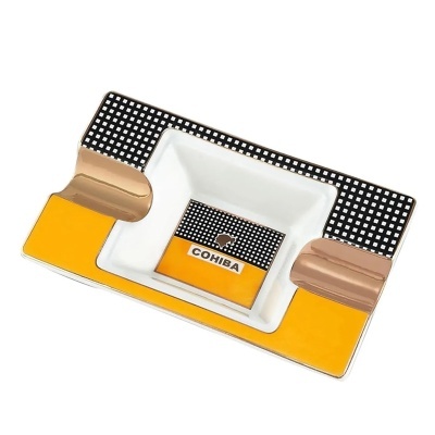 Cinzeiro de porcelana amarelo, branco, preto com padrão de quadrados e texto COHIBA