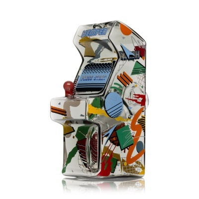 Objeto decorativo em forma de máquina arcade em vidro com padrões coloridos e texto