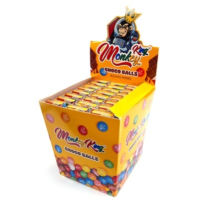 Expositor amarelo de caixas de papel para enrolar Monkey King Choco Balls com decoração colorida e macaco com coroa.