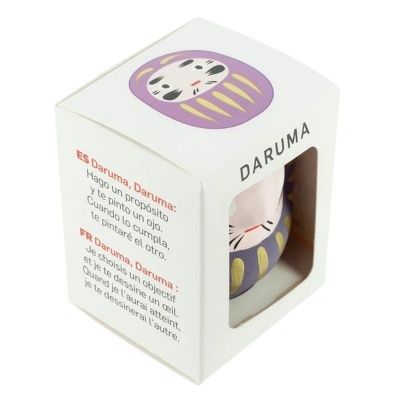Caixa branca com boneco Daruma lilás visível por janela transparente