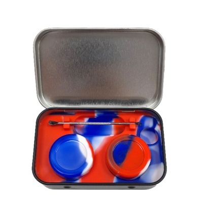 Estojo metálico aberto com dois recipientes de silicone bicolor e ferramenta de limpeza.