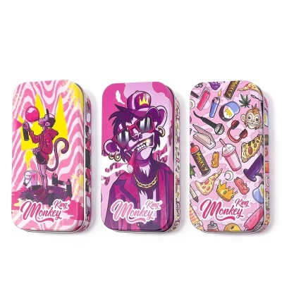 Três latas decoradas com macacos e texto Monkey King em tons de rosa