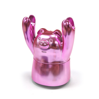 Figura decorativa de porco rosa metálico com braços levantados.