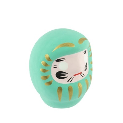 Mascote Daruma de cerâmica verde turquesa com decoração dourada e rosto pintado.