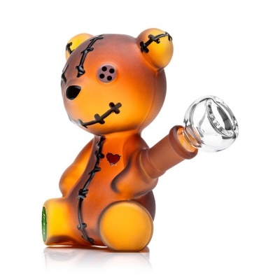 Peça decorativa de vidro em forma de urso alaranjado com detalhes em preto e coração vermelho.