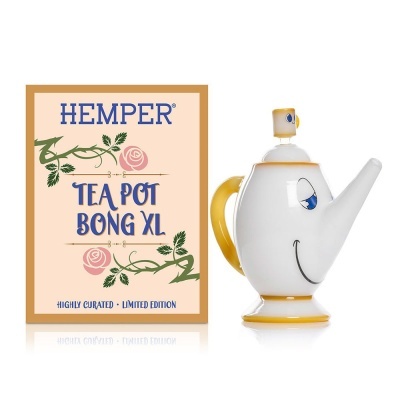 Chaleira branca e amarela com rosto sorridente ao lado de embalagem com texto HEMPER TEA POT BONG XL