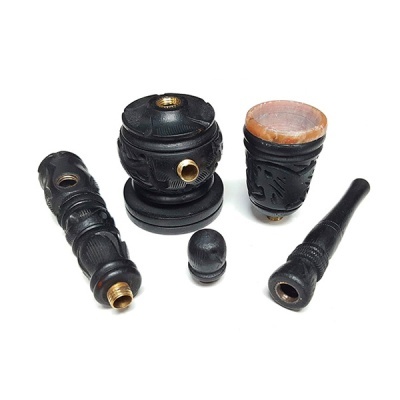 Peças desmontadas de um cachimbo em madeira escura com detalhes entalhados.