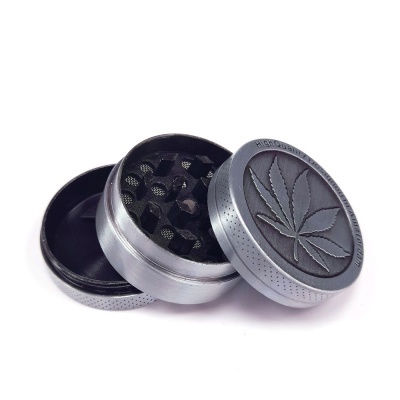 Triturador de ervas de metal com tampa preta e folha de cannabis gravada