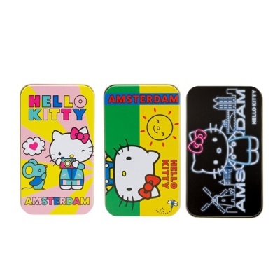 Três latas decorativas Hello Kitty coloridas com texto Amsterdam em fundo branco