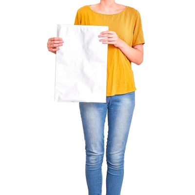 Pessoa de t-shirt amarela e jeans azuis a segurar envelope plástico branco