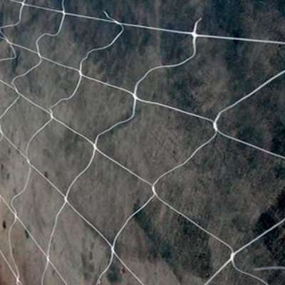 Rede de proteção branca instalada sobre superfície escura com padrão de malha losango