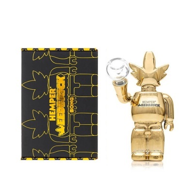 Boneco estilo Bearbrick dourado com caixa preta ilustrada