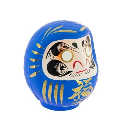 Boneco Daruma azul com detalhes dourados e pretos em fundo branco