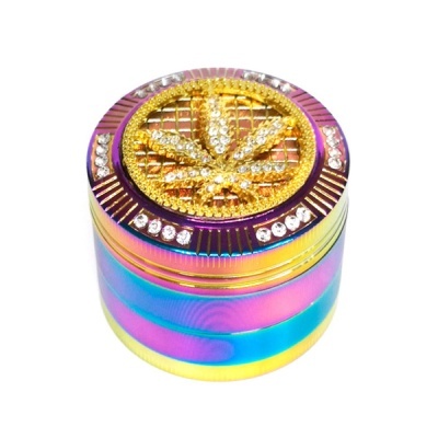 triturador metálico iridescente com folha de cannabis dourada e pedras brilhantes