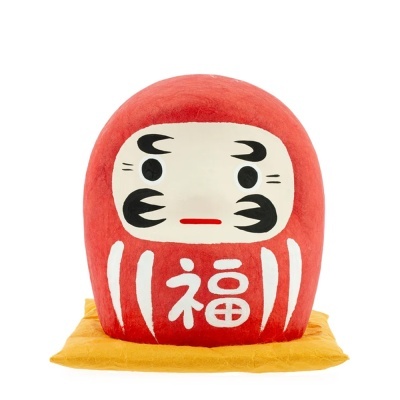 Boneco Daruma vermelho com rosto pintado e almofada amarela