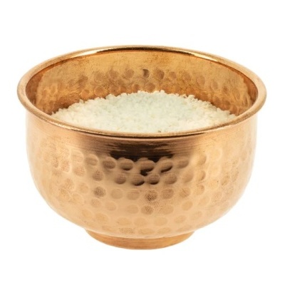 Taça de metal dourado com textura martelada cheia de arroz branco
