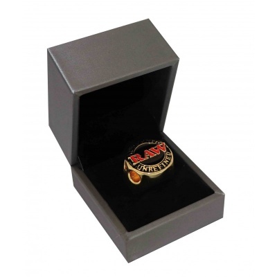 Anel RAW dourado numa caixa preta de joias