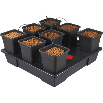 Conjunto de oito vasos quadrados pretos com bolas de argila expandida e tubos de irrigação numa bandeja preta.