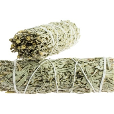 Feixes de ervas secas amarradas com fios brancos em fundo branco.