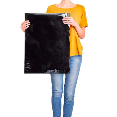 Pessoa segurando uma folha de plástico preto grande