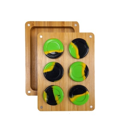 Seis discos redondos verde, preto e amarelo numa bandeja de madeira clara.