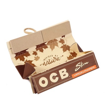 Pacote aberto de folhas para enrolar cigarro OCB Slim em cartão castanho e bege com texto