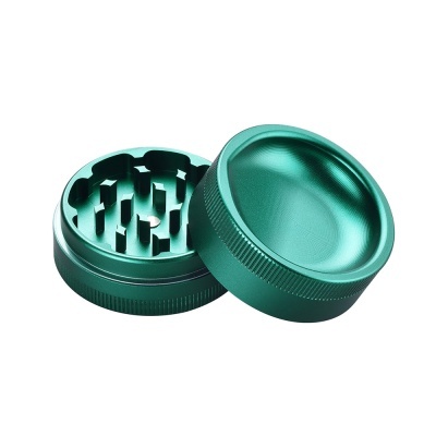 Moedor verde metálico aberto para ervas com dentes e textura lateral