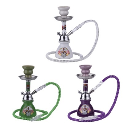 Três cachimbos de água decorados com caveiras coloridas em cores branco, verde e roxo
