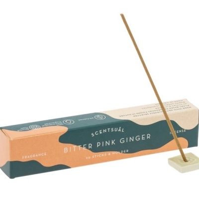 Incenso Scentsuál Bitter Pink Ginger com embalagem verde e laranja e suporte branco para incenso