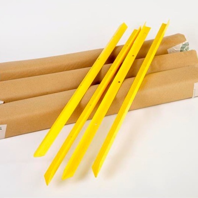 Peças amarelas longas de plástico sobre embalagens de papel castanho