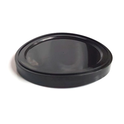 Tampão redondo preto em material plástico brilhante sobre fundo branco