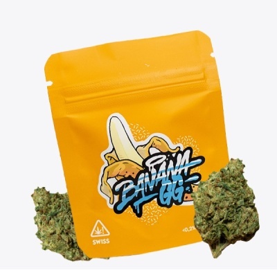 Embalagem amarela com ilustração de banana e texto BANANA GG com flores de cannabis ao lado