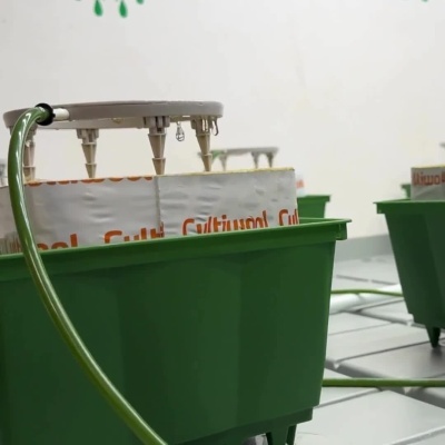 Caixas verdes com tampas cinzentas e bicos metálicos em instalação interior