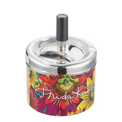Cinzeiro metálico com tampa giratória e base com padrão floral colorido e texto Frida Kahlo
