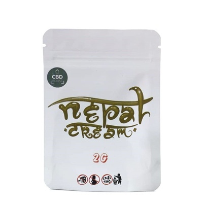Embalagem branca com texto dourado Nepal Cream e selo verde CBD LHouse