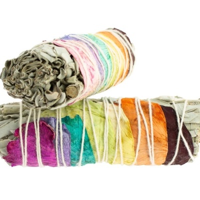Feixes de folhas de sálvia enrolados e presos com cordão branco e pétalas de flores coloridas