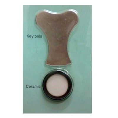 Kit com ferramenta metálica prateada e disco cerâmico branco e preto sobre fundo verde claro