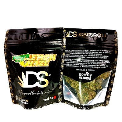 Embalagem preta com texto e janela transparente mostrando produto vegetal seco